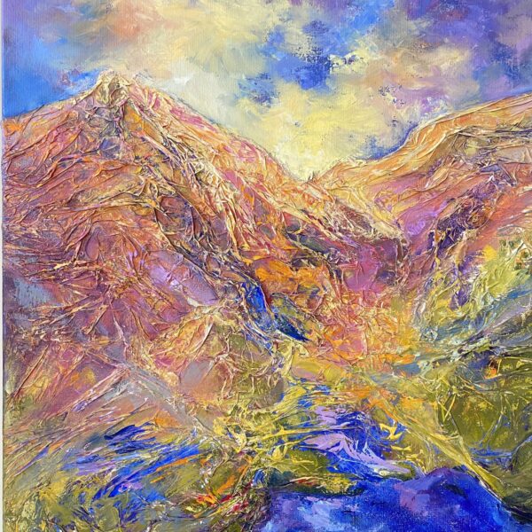 Mountain landscape with rugged peaks in shades of purple, beige, and blue under a partly cloudy sky.